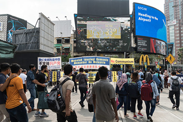 马来西亚退党服务中心于6月30日,在首都吉隆坡黄金三角区的繁华地带——武吉免登区,与民众一起声援3亿3千5百万三退勇士,吸引民众观看。(朱利达/大纪元)
