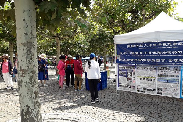 中国游客在德国景点了解法轮功真相。(明慧网)