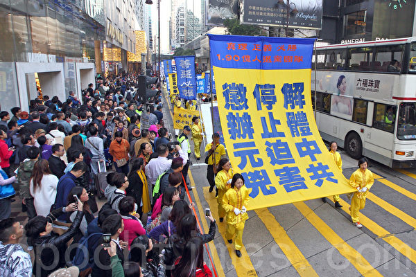 香港法轮功学员1月17日举行大型反迫害集会游行,逾千人的游行队伍途径九龙多个闹市区,呼吁各界三退解体中共,结束迫害,法办江泽民等元凶,吸引大批中外民众观看。(潘在殊/大纪元)