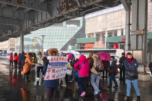 劝“三退”的义工在人群中打出真相展板“中国不等于中共” 、“爱国不等于爱党”、“中共活摘罪行”。 (李桂秀/大纪元)